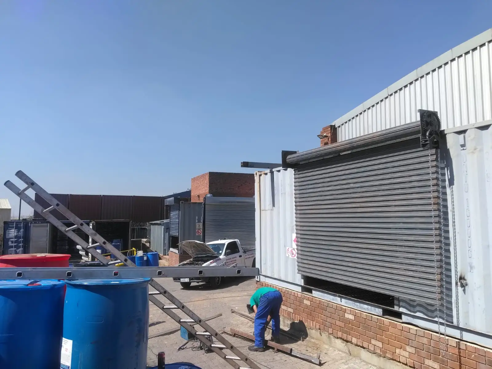 Industrial chain-operated shutter lifting system being inspected